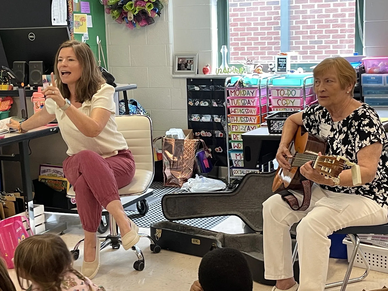 Brandy Taylor Strzelecki speaks to the class while Gloria Taylor Crone accompanies on guitar